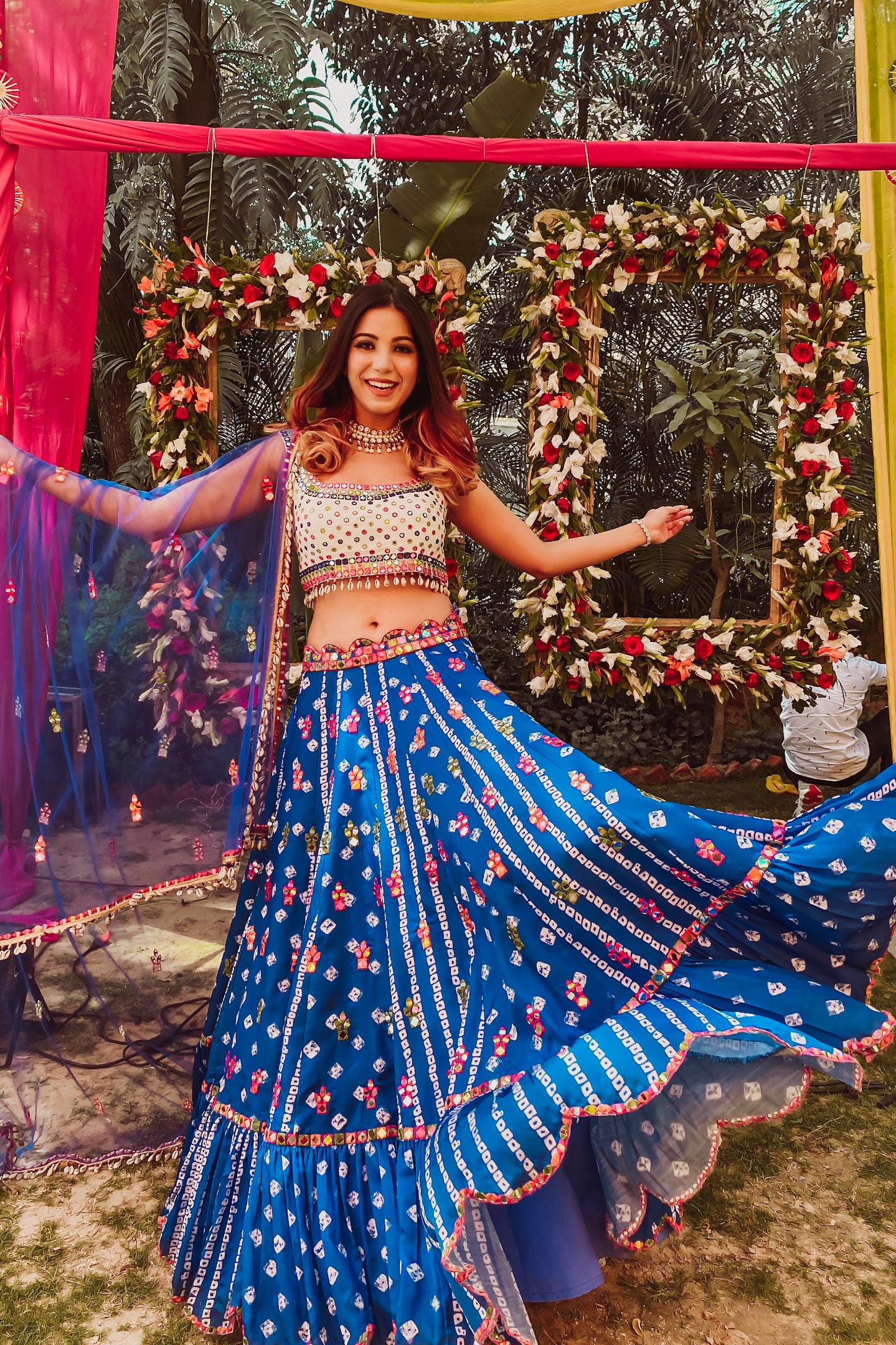 Photo of Couple posing with pretty decor with bride wearing cape lehenga